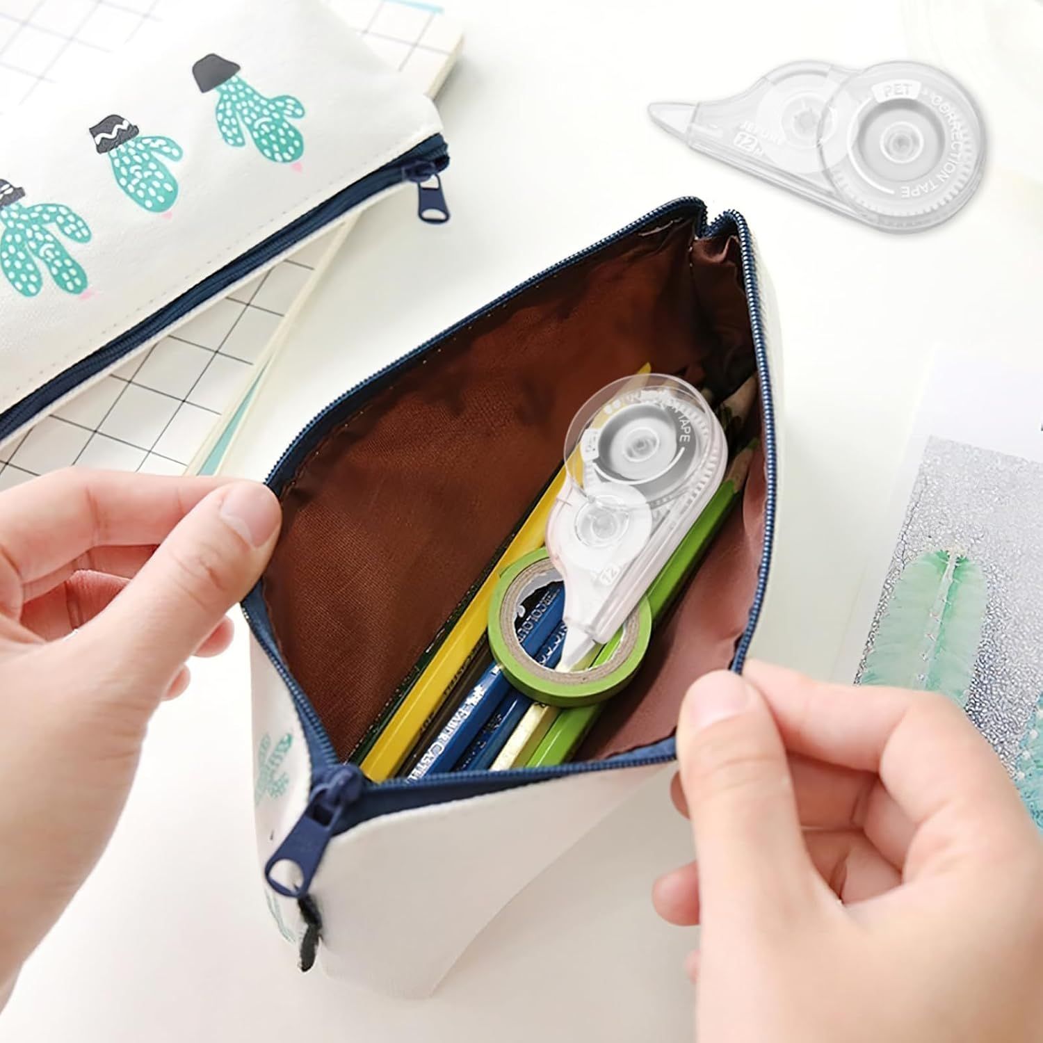 Demonstrates the product in a real-world setting, showing how the correction tape fits naturally into a student's or office worker's pencil case alongside other stationery items.