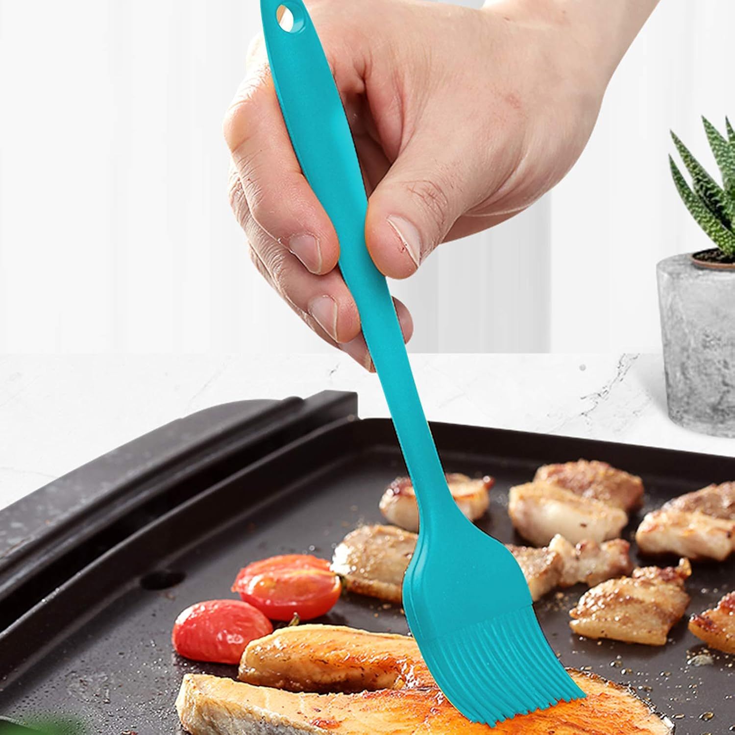 Demonstrates the product being used in a real-world cooking context to help shoppers visualize how the silicone brush works on a grill pan.