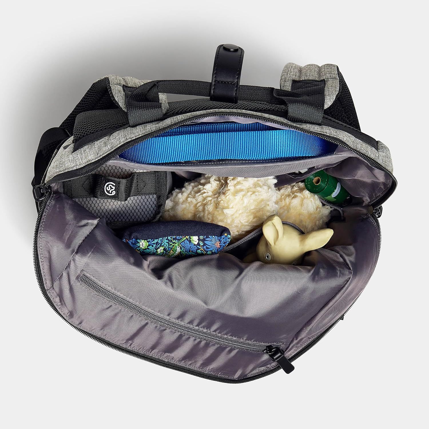 Shows what fits inside the backpack and demonstrates its storage capacity for pet supplies like toys, water bottles, and accessories.