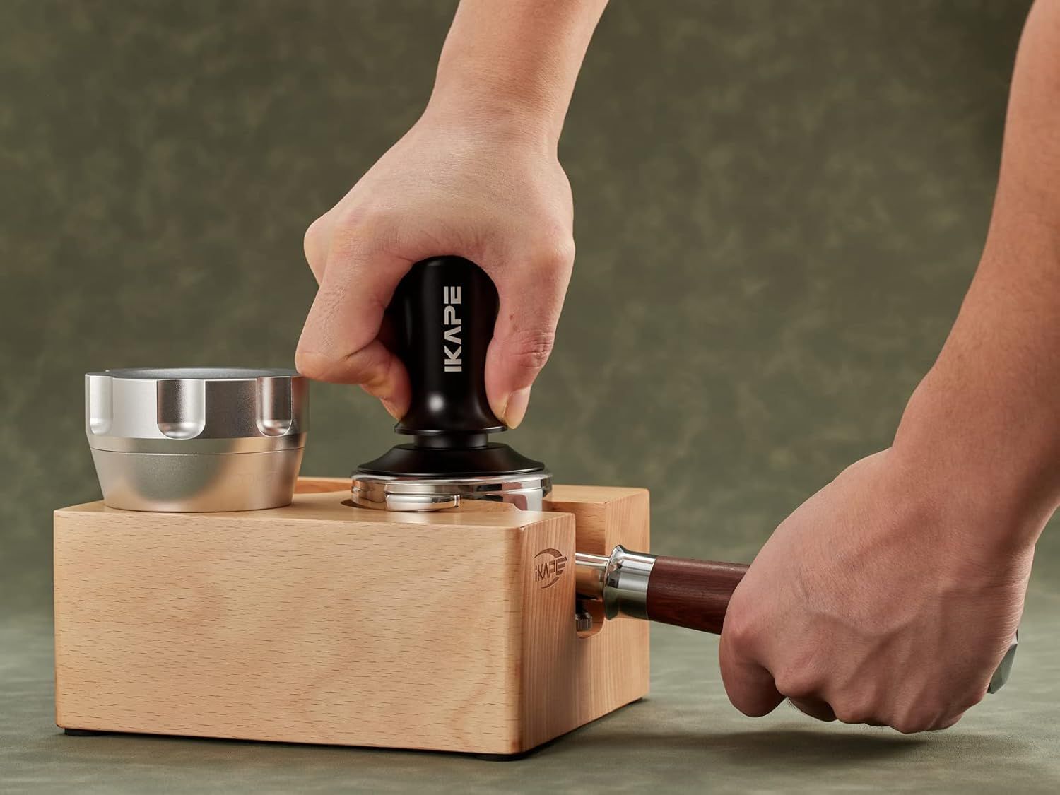 Demonstrates the tamper being used with a wooden tamping station, helping shoppers visualize the product in a real coffee-making workflow.