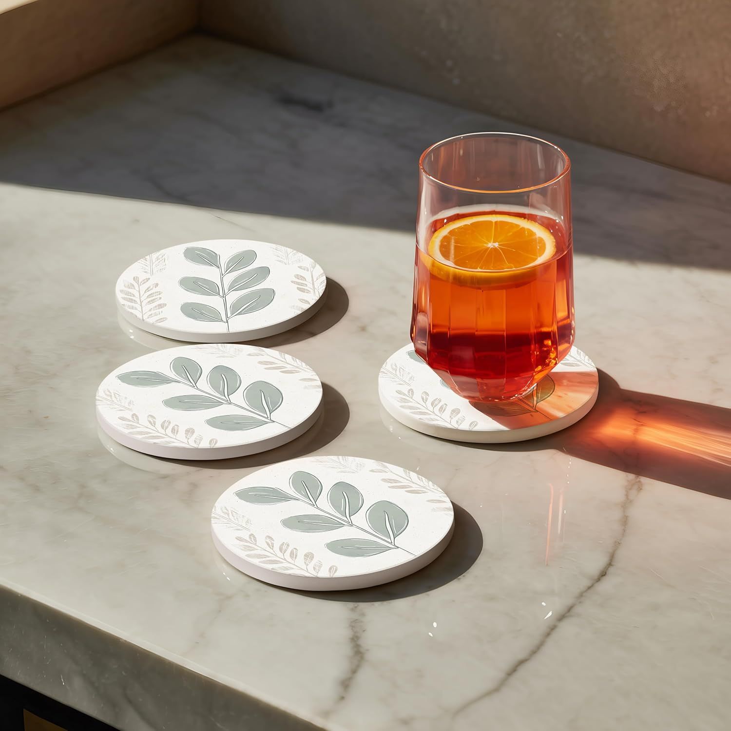 Shows the coasters in an authentic home setting with natural lighting and a drink to help shoppers visualize the product in their own space.