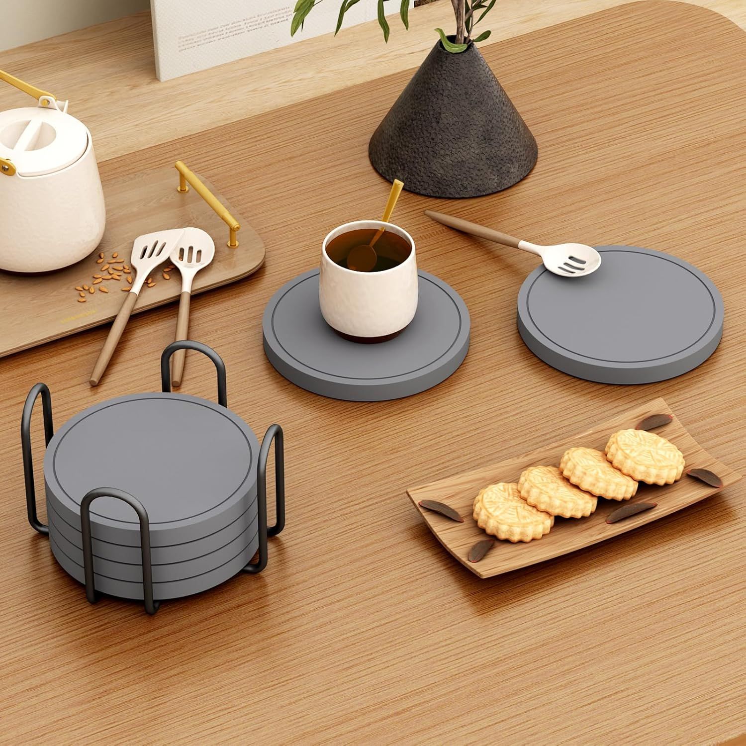 Shows the coasters in a real-world home environment on a wooden table with tea and snacks to help shoppers visualize the product in use.