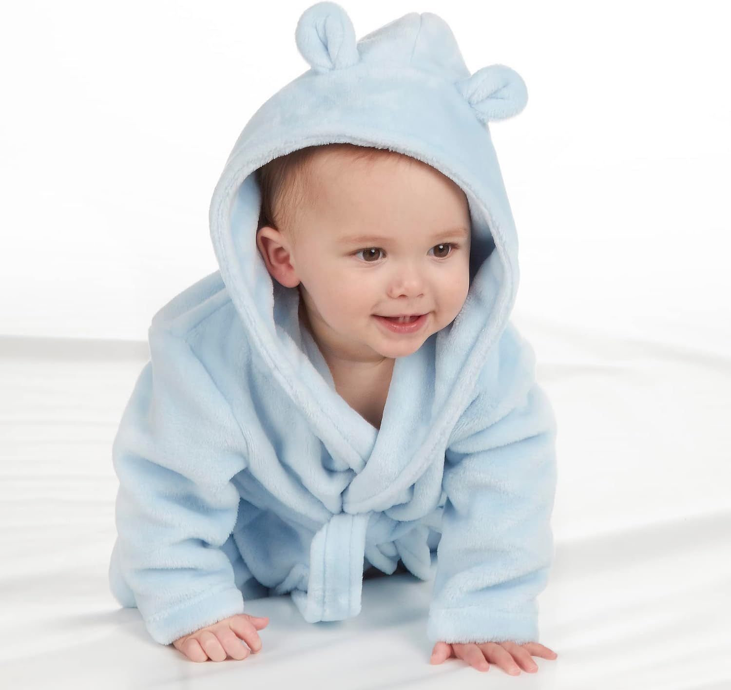 Shows the baby bathrobe being worn by a child in a real-world context to help shoppers visualize the product in use.