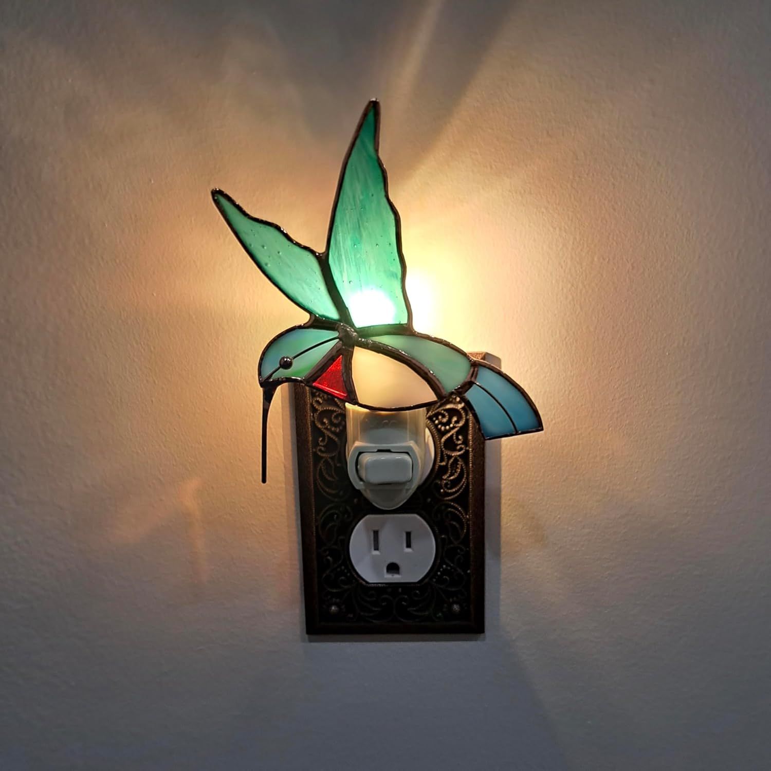 Displays the night light plugged in and glowing in a real-world environment to show its ambient lighting effect.
