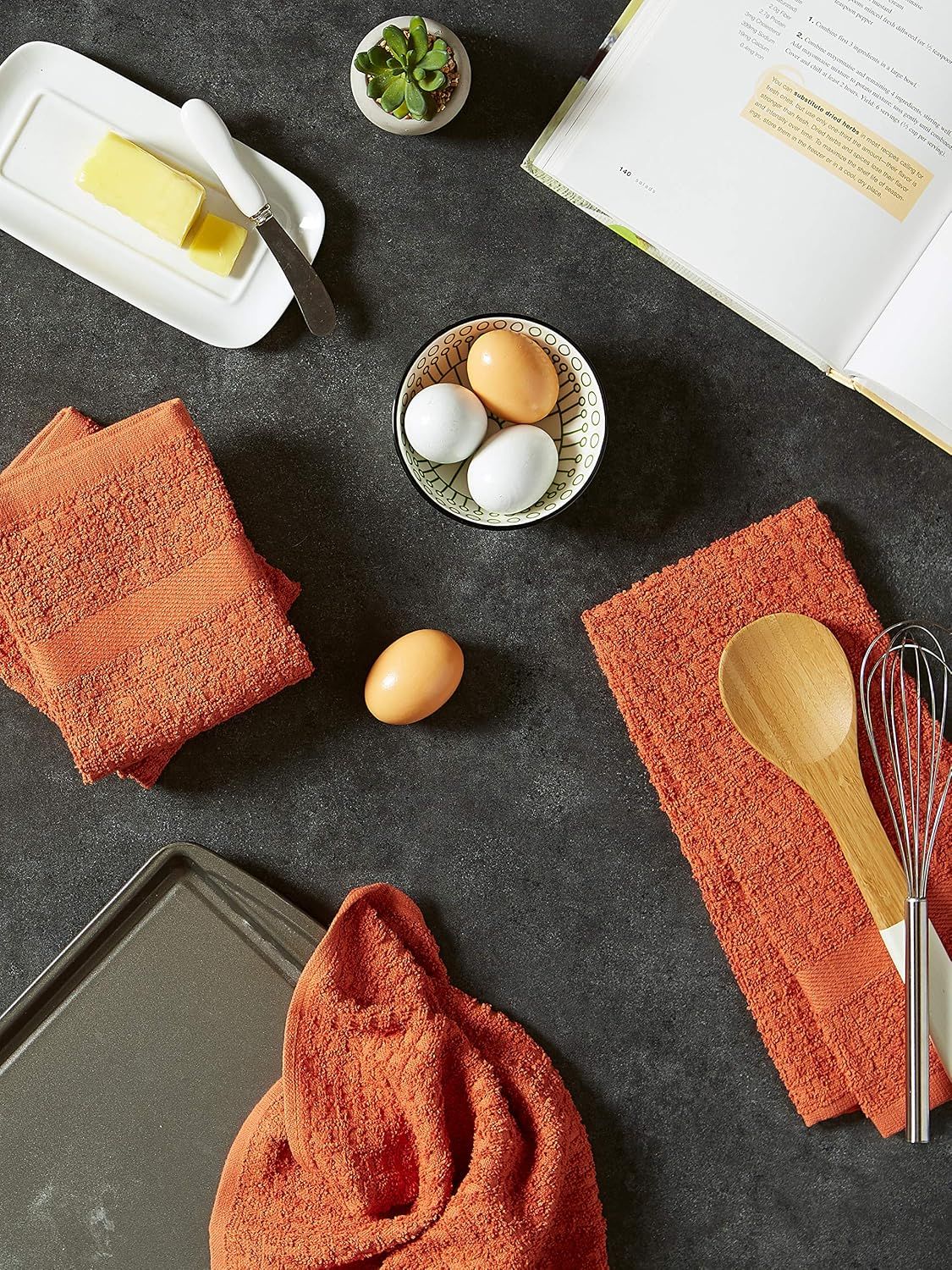 Demonstrates the towels in use during a baking scenario to help shoppers see the product in a relatable everyday context.