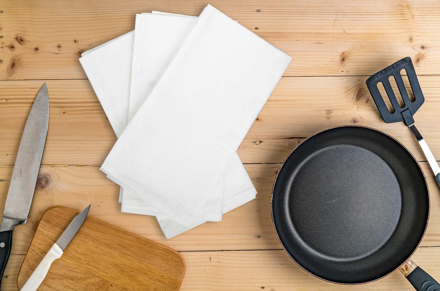 Shows the towels in a real kitchen setting with cooking tools to help shoppers visualize the product in use.