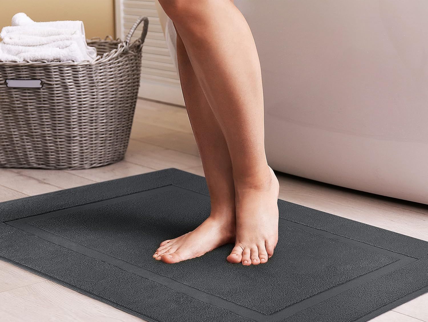 Shows the bath mat in use in a bathroom setting with feet standing on it, demonstrating its comfort and practical application.