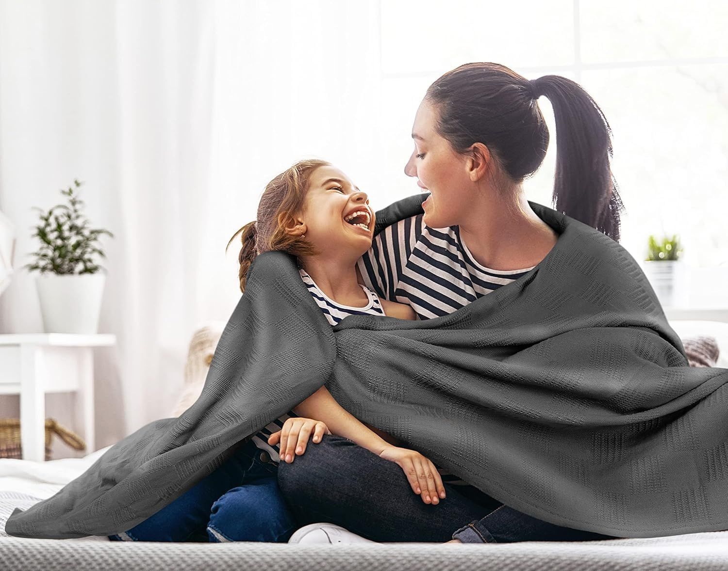 Shows the blanket in a real-world home setting with a mother and daughter sharing warmth, communicating comfort and family bonding without any text overlay.