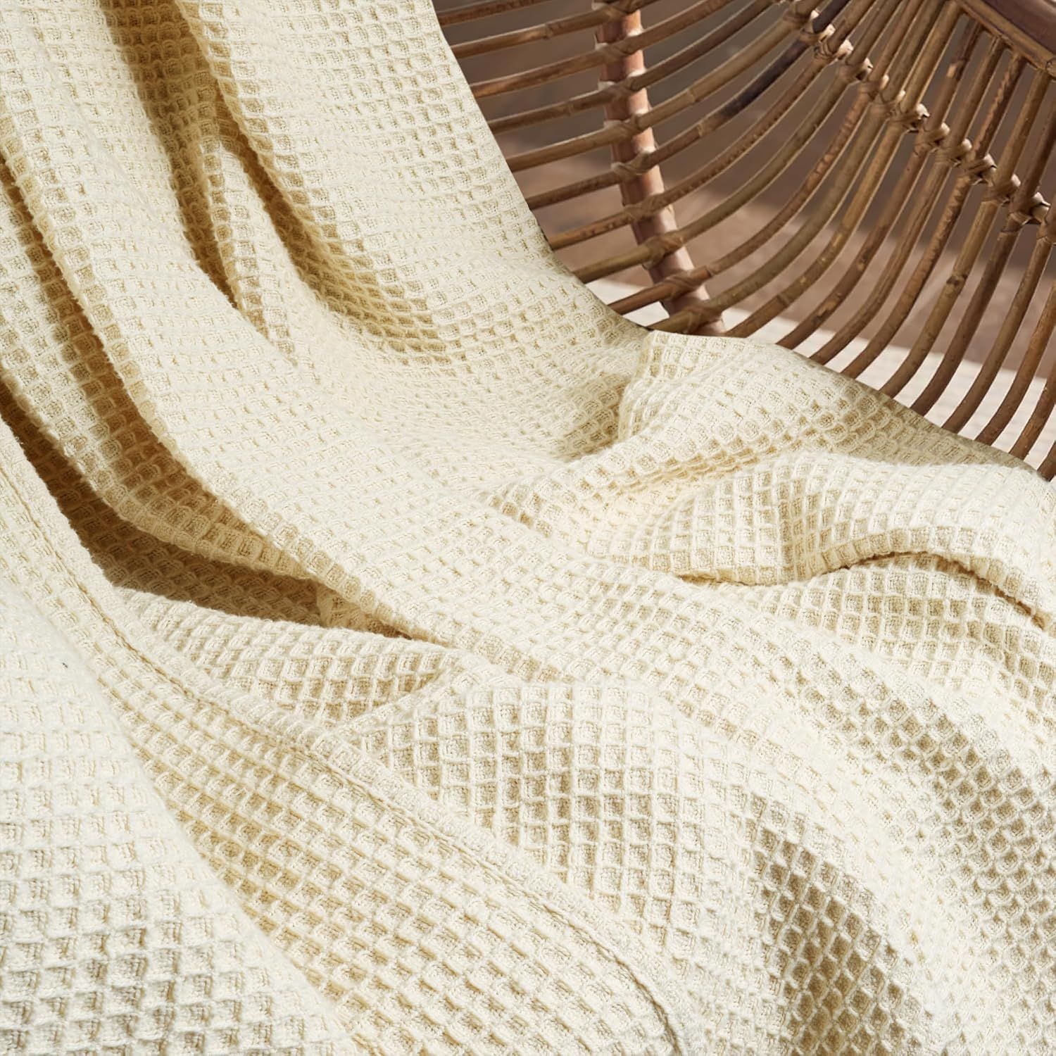 Showcases the waffle weave texture and drape of the blanket in a lifestyle setting to help shoppers appreciate the material quality and visual appeal.
