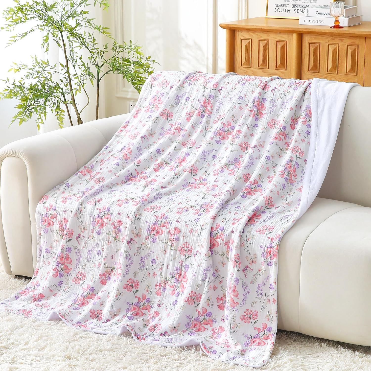 Shows the blanket draped over a sofa in a real-world home environment to help shoppers visualize the product in use.