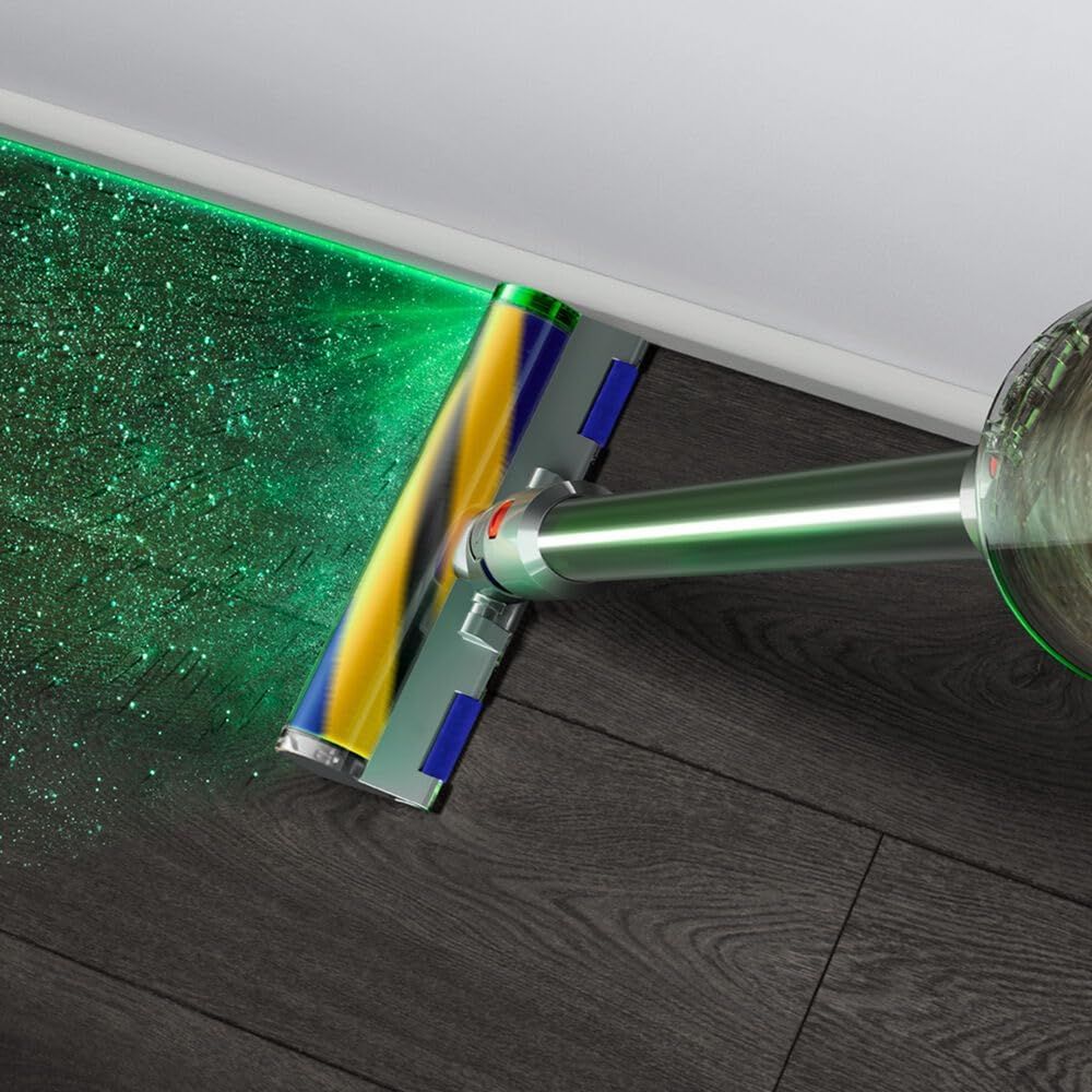 Shows the vacuum in use on hard floors with the green laser illuminating dust particles in a real-world context.