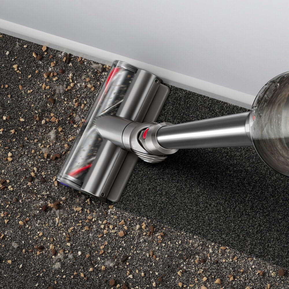 Displays the vacuum cleaning debris from carpet in a real-world setting without text overlay.