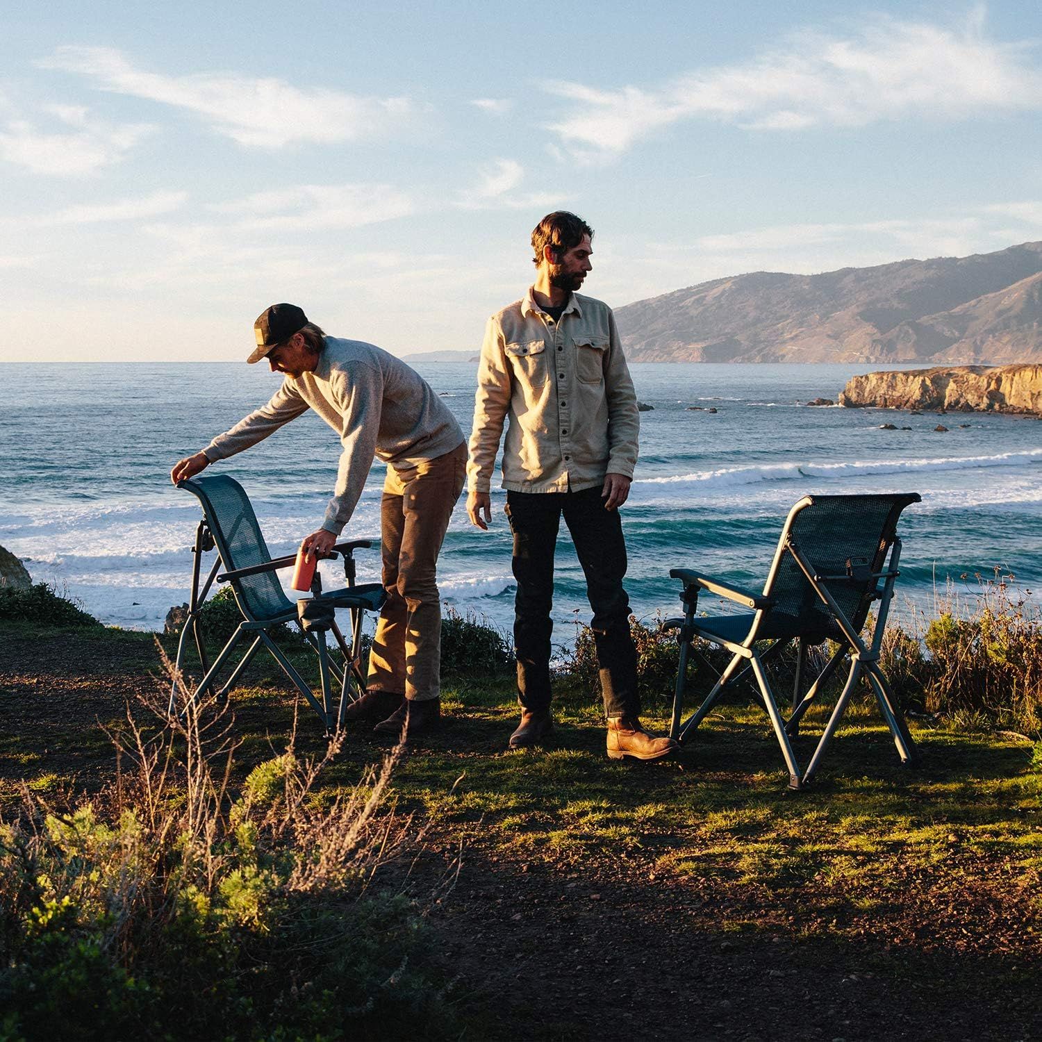 Shows the chairs being used in a scenic coastal outdoor setting to help shoppers envision the product in their own adventures.