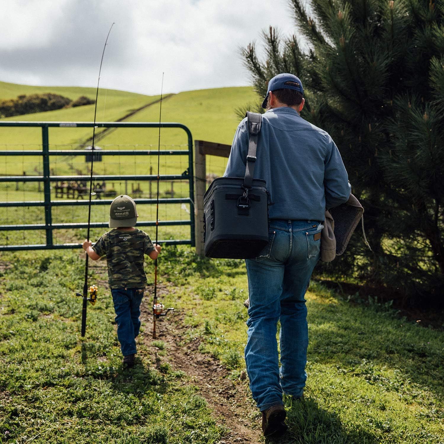 Demonstrates the cooler being carried hands-free in a real-world outdoor setting with no text, showing shoppers how portable and practical it is for activities like fishing.