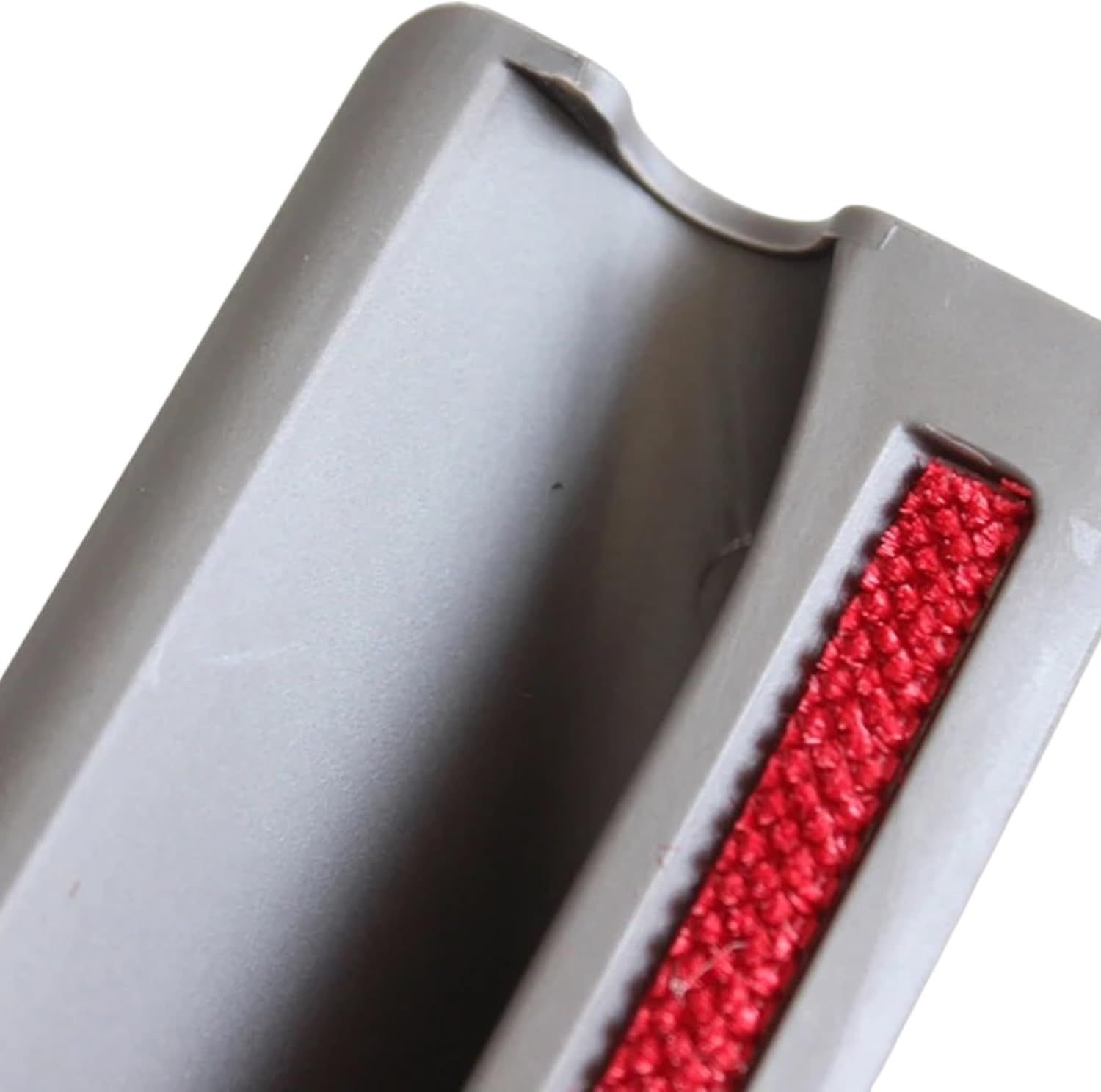 Shows a close-up detail of the red bristle strip component of the vacuum attachment to highlight its physical construction.
