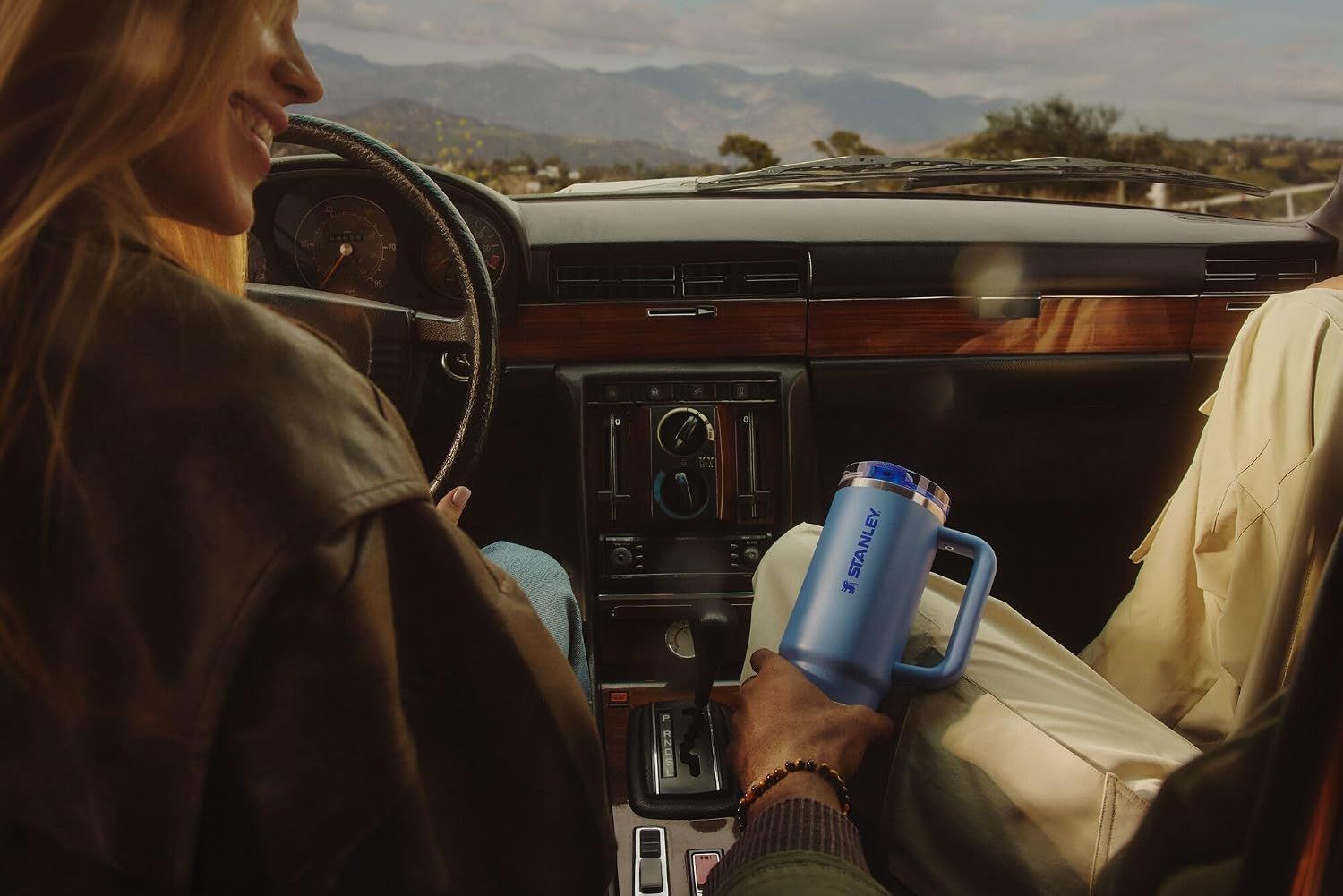 Demonstrates the product in a vehicle setting to show its suitability for travel and on-the-go hydration.