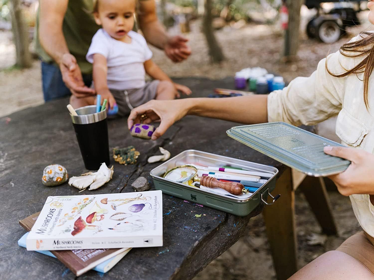 Shows the product being used to organize art supplies in a family outdoor setting, demonstrating practical everyday use.