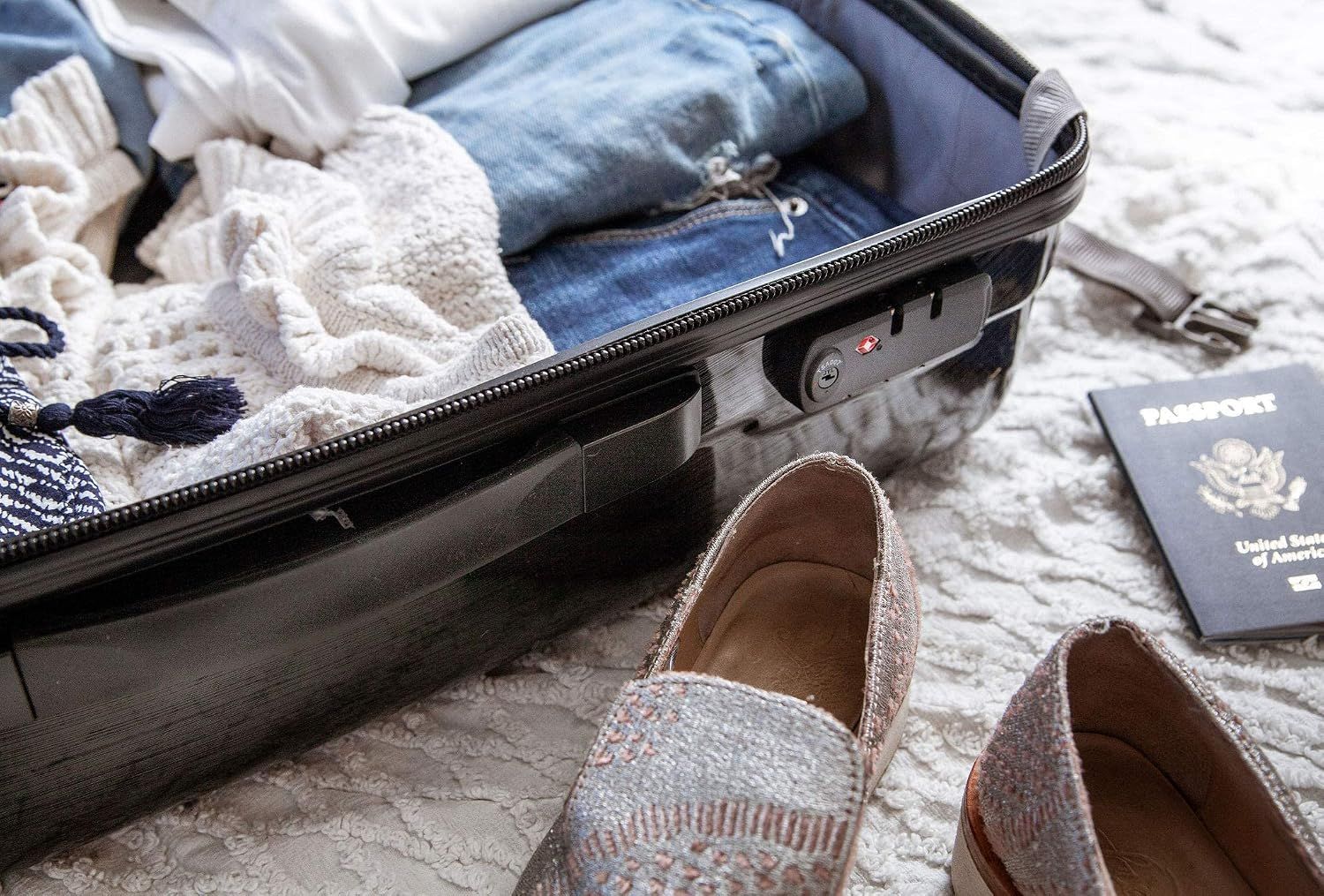 Shows the open suitcase in a real travel setting with clothes, shoes and a passport to help shoppers picture trip use.