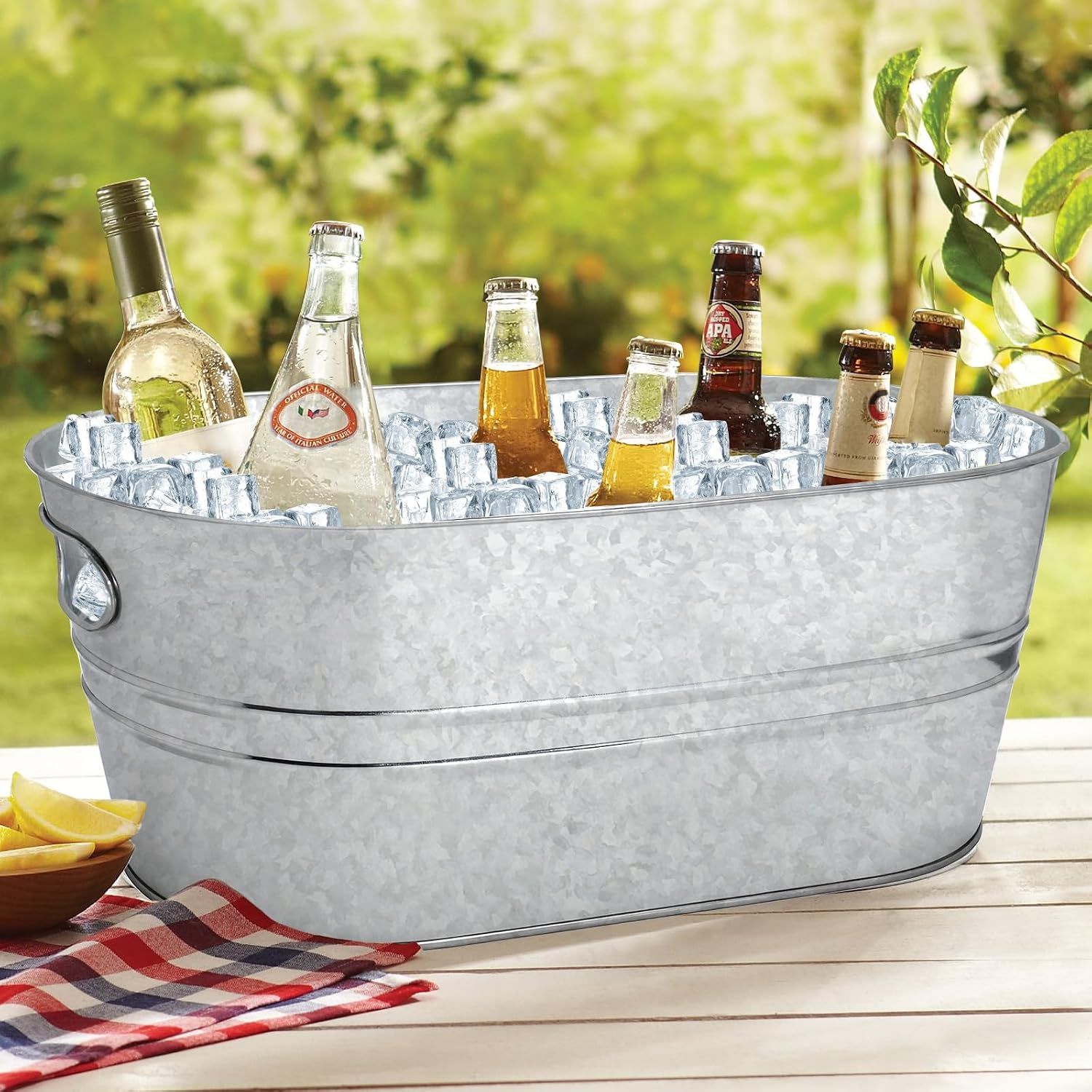 Shows the tub filled with ice and drinks on an outdoor table to convey its everyday serving use.