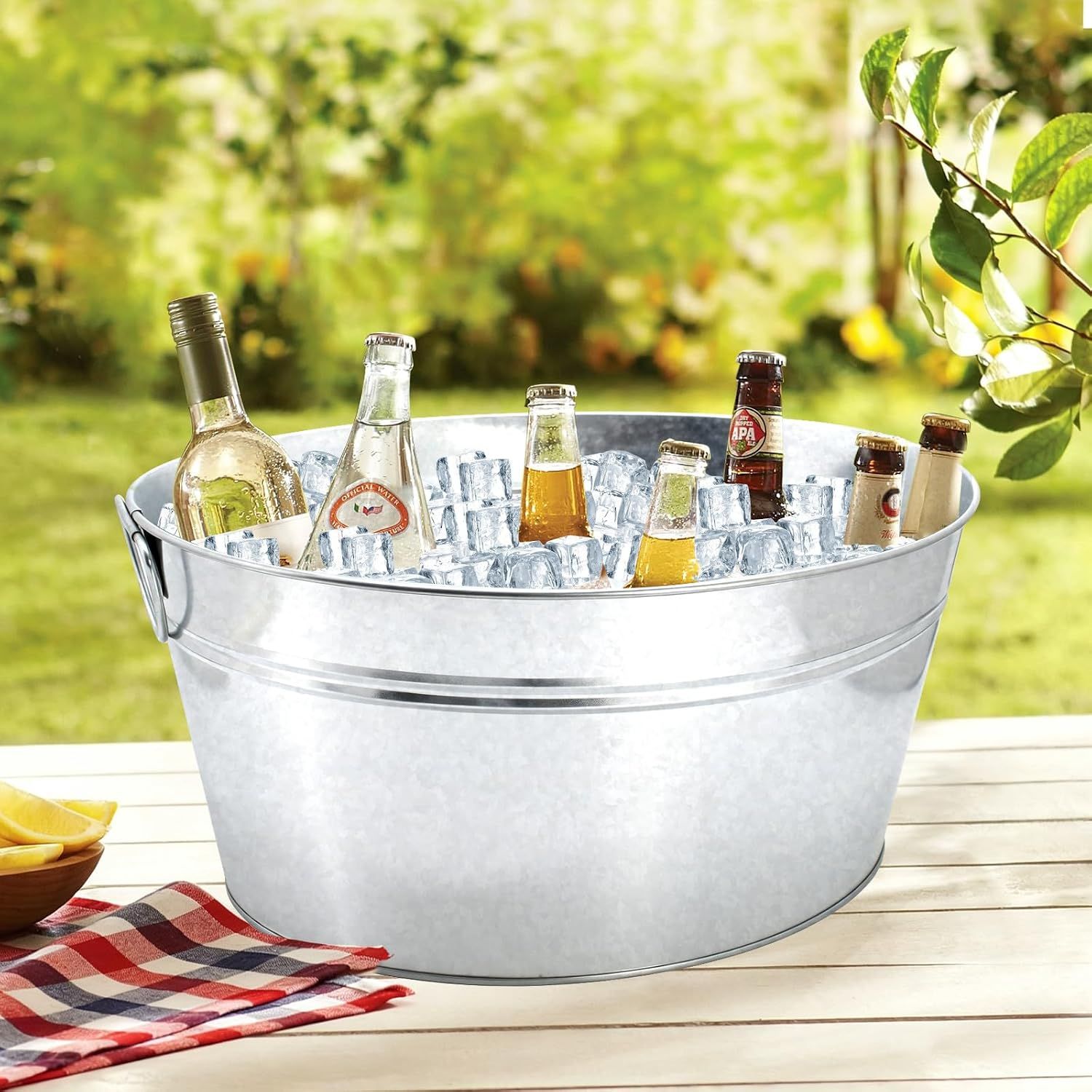 Shows the tub filled with ice and drinks outdoors to convey its ample size for parties.