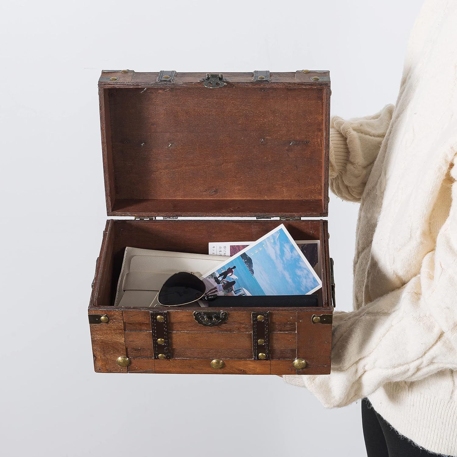 Shows the trunk held in a real-life setting with personal items stored inside, helping shoppers picture it as a keepsake or storage box without any text distraction.