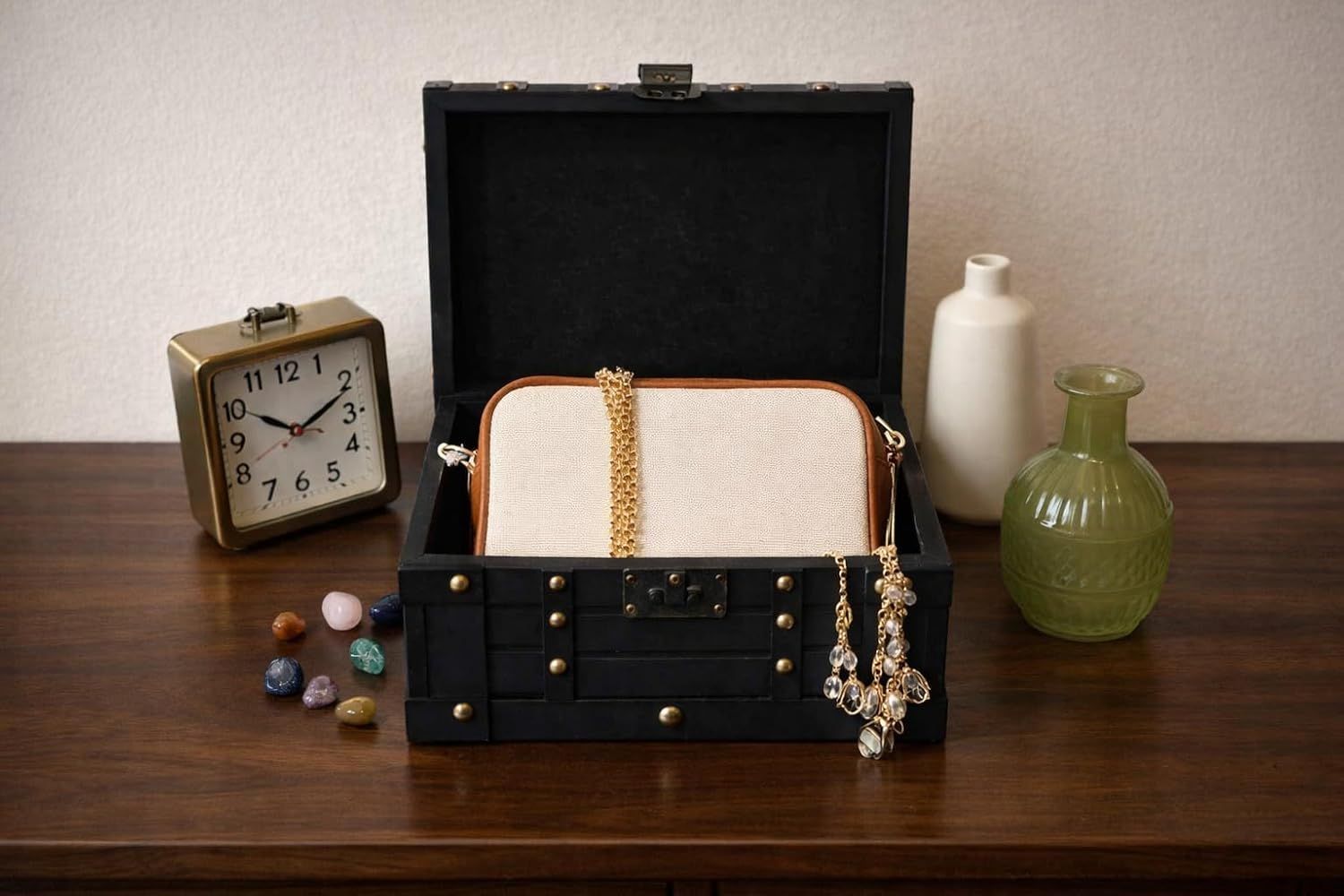 Shows the chest holding a purse, jewelry, and decor to demonstrate its multiple storage and display uses.