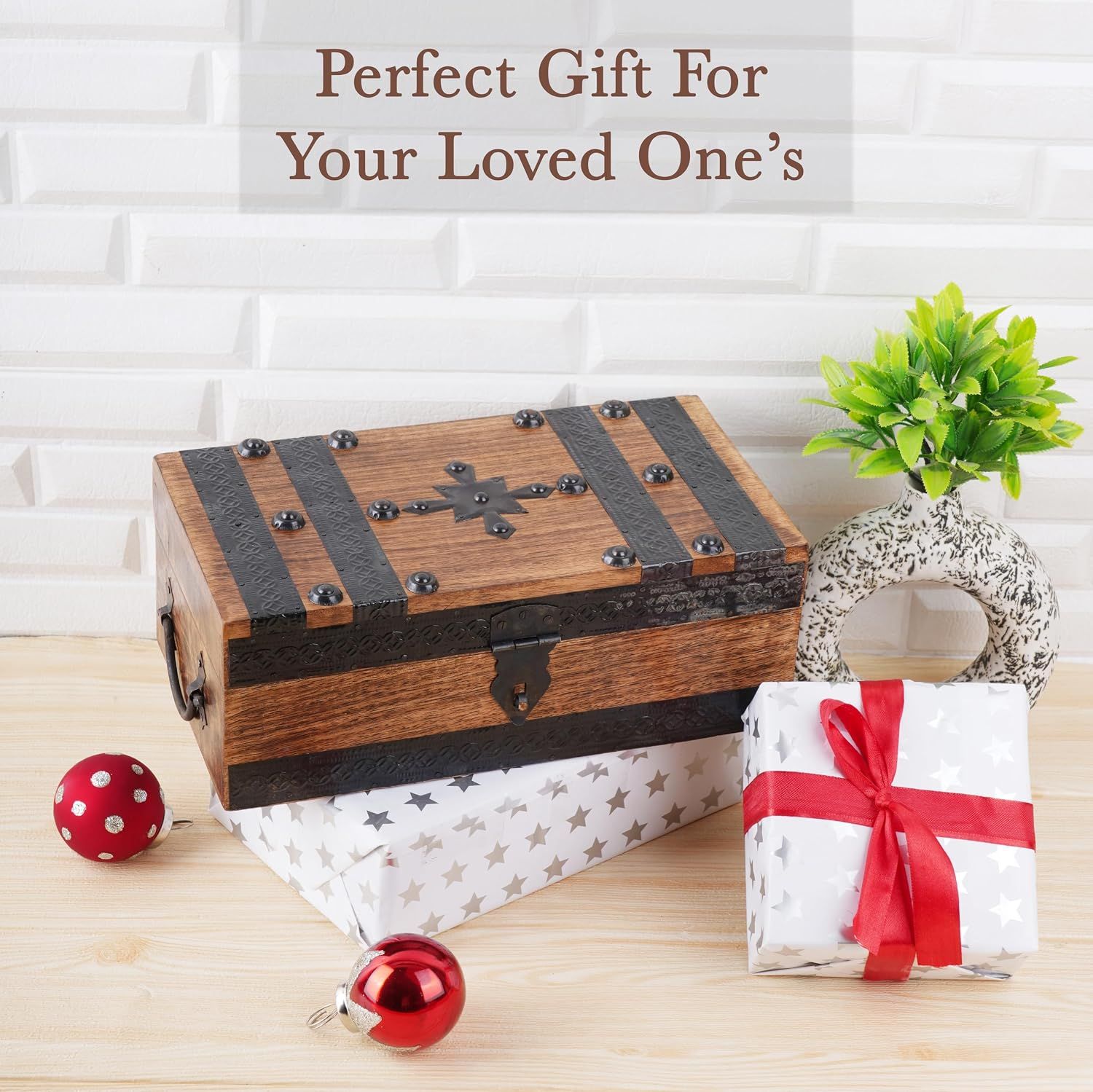 Positions the wooden treasure chest as a gift for a loved one, reinforced by wrapped gift boxes, red ribbon, and holiday ornaments. Uses one lifestyle scene and one headline to communicate that this…