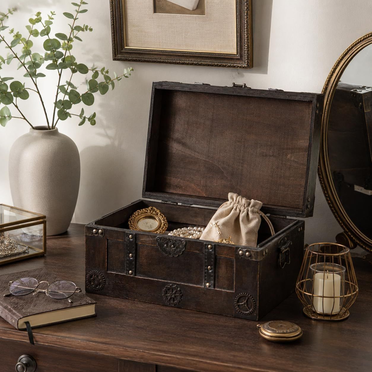 Shows the wooden keepsake trunk styled naturally on a vanity with jewelry inside, helping shoppers picture it in their own home decor.