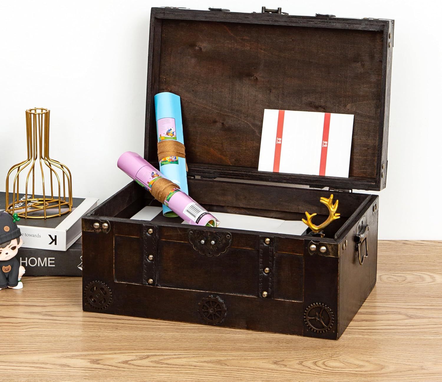 Shows the vintage wooden trunk styled in a real home setting with rolled papers and decor, helping shoppers picture it as a stylish storage piece.