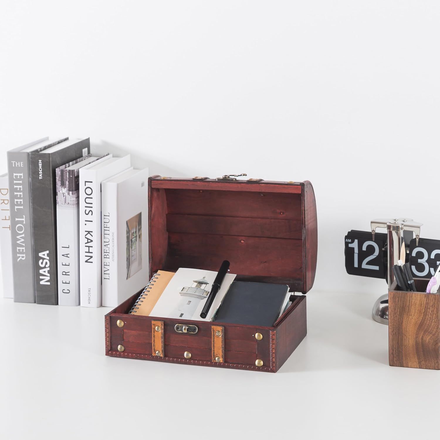 Shows the open chest filled with notebooks and pens to demonstrate its storage use on a desk.