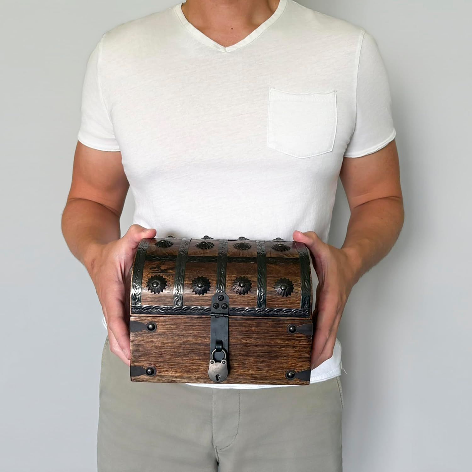 Shows the treasure chest being held by a person to convey its handheld size and rustic pirate style without any text overlay.
