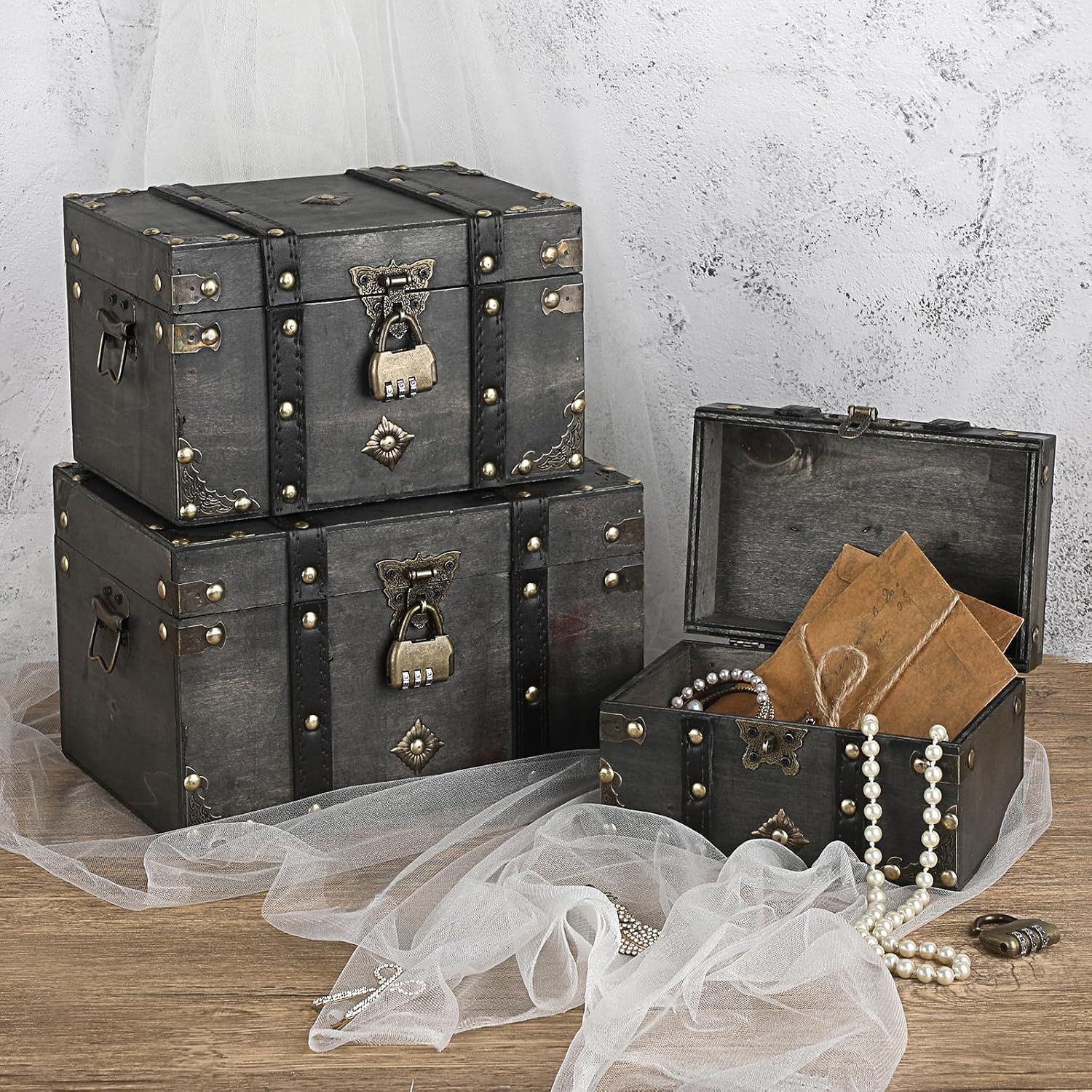 Shows several chest sizes together so shoppers can see the product line options. Highlights the vintage look and storage use of the chests in a styled scene.