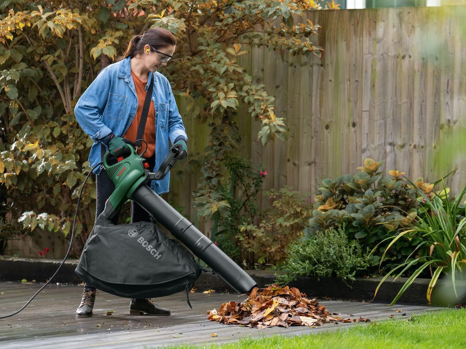 Shows the blower vacuum clearing leaves on a patio to convey easy garden cleanup in one scene. Shows the product in use in a real backyard setting.