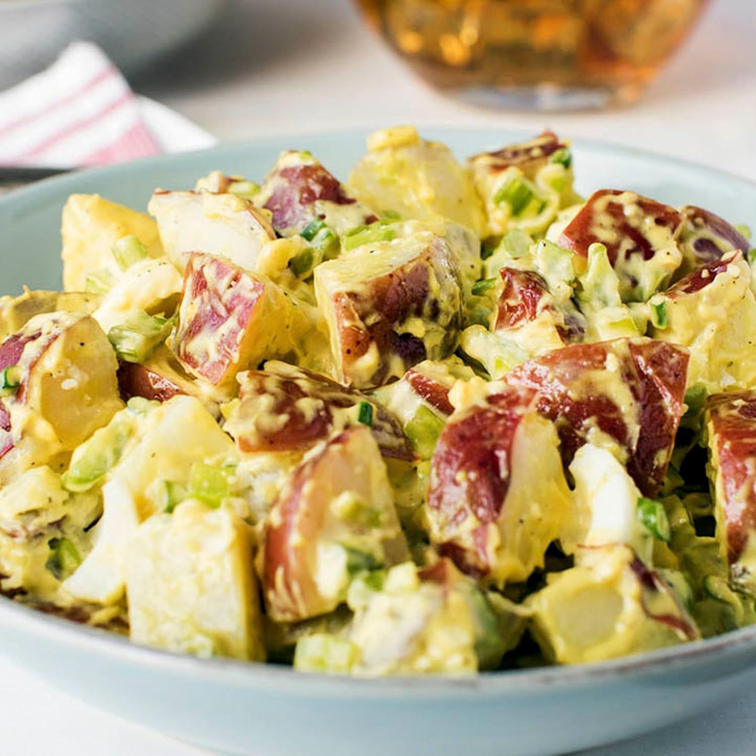 Shows the mustard used as a dressing ingredient in potato salad. Shows a appetizing potato salad serving with no text overlay.
