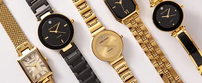 Displays a range of Anne Klein gold and black watches side by side to show the breadth of the collection.