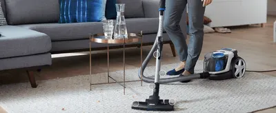 Zooms in on multiple points along the hose and floor nozzle to show the tool's flexible, reachable design.