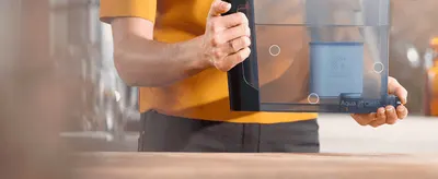 Shows shoppers how easily the AquaClean filter can be installed or removed from the machine's water tank. Reinforces that the filter is simple and hassle-free to fit into the machine.