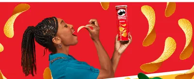 Shows a real person enjoying the chip to create an appetizing, relatable snacking moment.