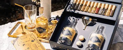 Shows the DIY gin kit styled in an outdoor lifestyle setting to make the product feel premium and aspirational.