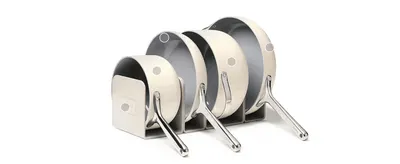 Shows every pan in the set together with its storage rack, so shoppers see what they receive. Uses hotspot dots on each piece so shoppers can explore the parts of the set.