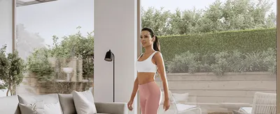 Shows a woman in workout wear in a calm home setting to help shoppers picture the product fitting into their everyday life.