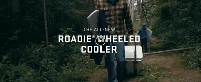 Introduces the all-new Roadie Wheeled Cooler in a real outdoor setting to highlight its easy, wheeled portability.