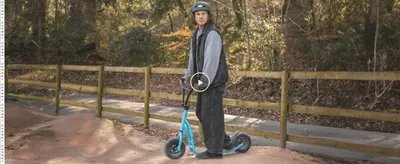 Shows the scooter being ridden outdoors to help shoppers picture real-world use.