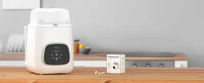 Shows the washer and detergent tablets in a real kitchen setting to help shoppers picture it in their own home.