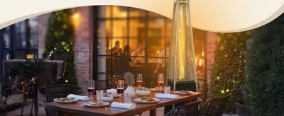 Shows the heater warming an evening dining scene to help shoppers envision using it for entertaining outdoors.