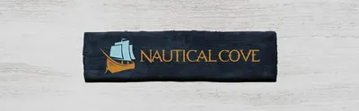 Presents the Nautical Cove logo on a weathered wooden sign to establish brand identity and a maritime-inspired brand personality that builds recognition and trust with shoppers.