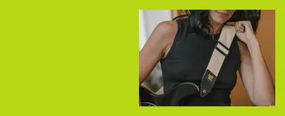 Shows a player wearing the strap with a guitar to help shoppers picture the product in real use.