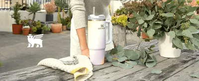 Shows the tumbler in a relaxed outdoor setting to build an aspirational, lifestyle-oriented association with the product.