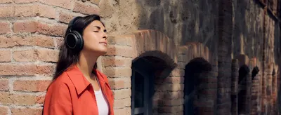 Shows the wireless headphones worn during a calm outdoor moment to help shoppers imagine comfortable everyday use.