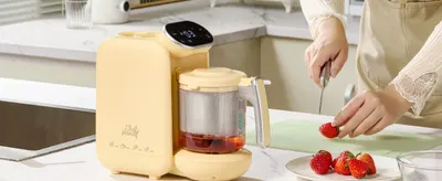Shows the product in a real-world kitchen environment with a parent preparing food, helping shoppers envision the product in their daily routine.
